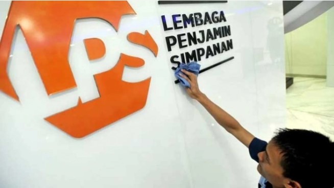 Karyawan membersihkan logo Lembaga Penjamin Simpanan (LPS) di Jakarta. [Antara]