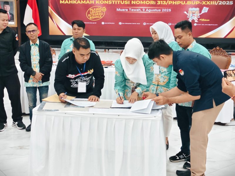 Saksi Paslon 01, Rusiani saat menandatangani berita acara rekapitulasi. Sementara saksi paslon 02 tolak tanda tangan, Sabtu(9/8/25. Foto./Deni