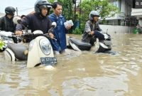 Warga mendorong sepeda motor melewati banjir yang menggenangi kawasan Kuta, Badung, Bali, Rabu (10/9/2025). [ANTARA FOTO/Fikri Yusuf/nym]