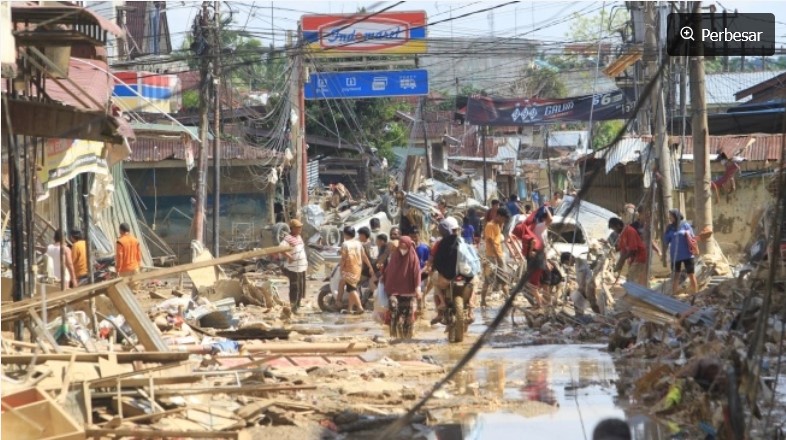 Sejumlah warga melintas di dekat puing-puing yang terbawa arus banjir di kawasan Desa Bukit Tempurung, Kota Kuala Simpang, Kabupaten Aceh Tamiang, Aceh, Rabu (3/12/2025). [ANTARA FOTO/Syifa Yulinnas/nz] 