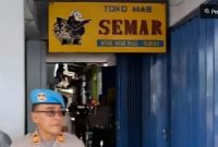 Personel Polri berjaga di depan sebuah toko emas dalam penggeledahan terkait tindak pidana pencucian uang (TPPU) atas tindak pidana asal menampung, memanfaatkan, melakukan pengolahan dan/atau pemurnian, penjualan emas yang berasal dari pertambangan tanpa izin atau ilegal di Nganjuk, Jawa Timur, Kamis (19/2/2026).(Dittipideksus Bareskrim Polri) 