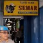 Personel Polri berjaga di depan sebuah toko emas dalam penggeledahan terkait tindak pidana pencucian uang (TPPU) atas tindak pidana asal menampung, memanfaatkan, melakukan pengolahan dan/atau pemurnian, penjualan emas yang berasal dari pertambangan tanpa izin atau ilegal di Nganjuk, Jawa Timur, Kamis (19/2/2026).(Dittipideksus Bareskrim Polri) 