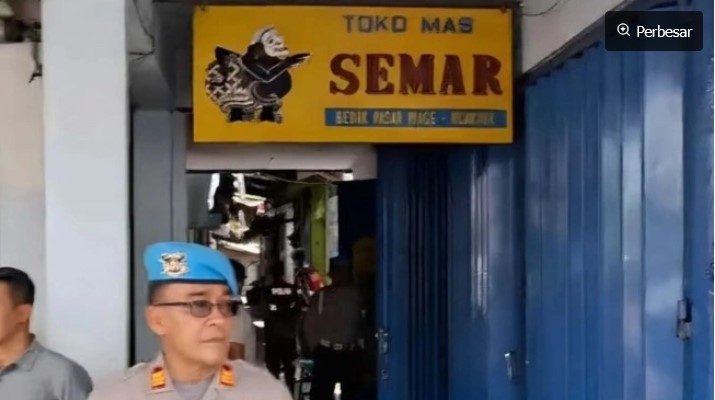 Personel Polri berjaga di depan sebuah toko emas dalam penggeledahan terkait tindak pidana pencucian uang (TPPU) atas tindak pidana asal menampung, memanfaatkan, melakukan pengolahan dan/atau pemurnian, penjualan emas yang berasal dari pertambangan tanpa izin atau ilegal di Nganjuk, Jawa Timur, Kamis (19/2/2026).(Dittipideksus Bareskrim Polri) 