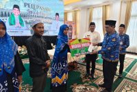 Bupati Shalahuddin ketika memberikan uang saku kepada salah seorang jamaah umroh yang diberangkatkan, Rabu(25/3/2026). Foto.Deni