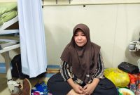 Mila(istri korban) menunggu di samping korban. Foto Dadang