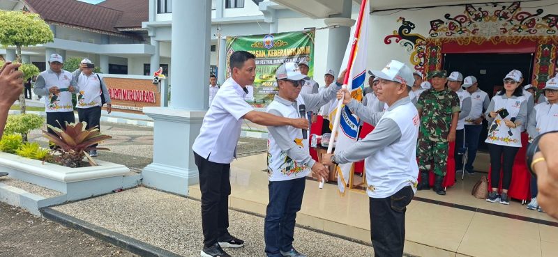 Bupati Heriyus menyerahakn bendera kontingen FBIM 2026 Mura  saat melepas keberangkatan peserta di halaman Kantor Bupati Mura, Rabu (13/5/2026). (Foto : 1tulah.com)