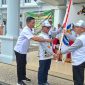 Bupati Heriyus menyerahakn bendera kontingen FBIM 2026 Mura  saat melepas keberangkatan peserta di halaman Kantor Bupati Mura, Rabu (13/5/2026). (Foto : 1tulah.com)