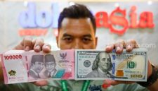 Petugas salah satu tempat penukaran mata uang asing menunjukkan uang rupiah dan dollar AS di Jakarta, Selasa (19/5/2026). [Suara.com/Alfian Winanto] 