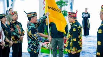 Gubernur Kalimantan Tengah Agustiar Sabran menyerahkan bendera kontingen secara simbolis kepada Ketua Umum LPPD Kalimantan Tengah Guntur Talajan saat pelepasan Kontingen PESPARAWI Nasional XIV menuju Manokwari, Papua Barat, di Istana Isen Mulang, Palangka Raya, Minggu (14/6/26).