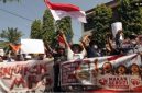Massa aksi membawa poster dan spanduk saat menggelar aksi damai mendukung keberlanjutan Program Makan Bergizi Gratis (MBG) di Trenggalek, Jawa Timur, Senin (22/6/2026). ANTARA FOTO/Destyan Sujarwoko].