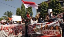 Massa aksi membawa poster dan spanduk saat menggelar aksi damai mendukung keberlanjutan Program Makan Bergizi Gratis (MBG) di Trenggalek, Jawa Timur, Senin (22/6/2026). ANTARA FOTO/Destyan Sujarwoko].