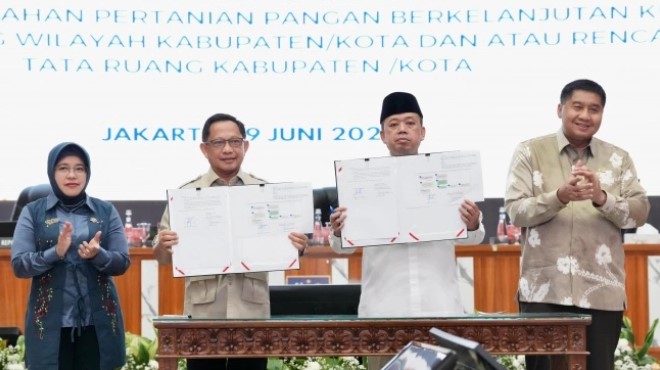 Menteri Dalam Negeri (Mendagri) Muhammad Tito Karnavian bersama Menteri Agraria dan Tata Ruang/Kepala Badan Pertanahan Nasional (ATR/BPN) Nusron Wahid menandatangani Surat Edaran Bersama (SEB). (Dok: Kemendagri) 