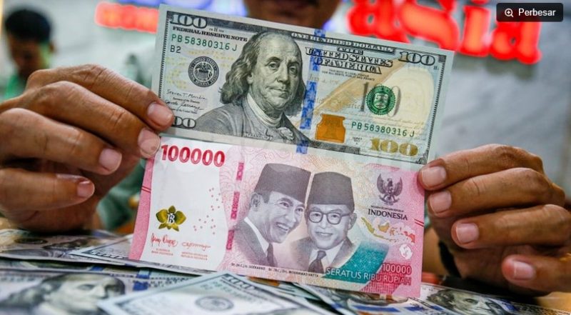 Petugas salah satu tempat penukaran mata uang asing menunjukkan uang rupiah dan dollar AS di Jakarta. [Suara.com/Alfian Winanto] 