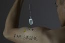 Seorang pria maskulin memamerkan tato bertuliskan “I Am Strong” di lengannya. (Pexels/Mike Murray)