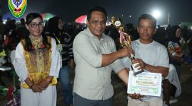 Wakil Ketua I DPRD Kabupaten Seruyan, Harsandi, menyerahkan tropy kepada salah satu pemenang lomba dalam kegiatan Danau Sembuluh Ethnic Festival (DSEF) 2026.