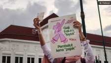 Peserta Aksi Suara Ibu Indonesia membentangkan poster berisi kritik terhadap kebijakan pengenaan PPN sebesar 11 persen pada produk pembalut di kawasan Titik Nol Kilometer Yogyakarta, Jumat (30/10/2026). [Suara.com/Hiskia] 